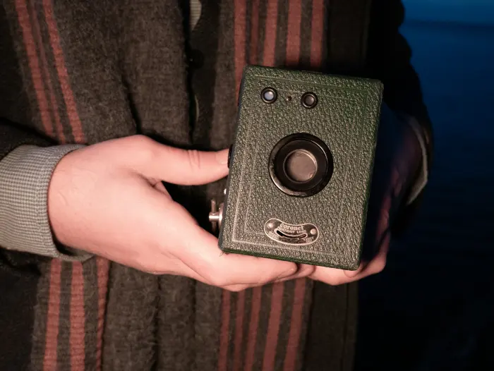 Hands holding an antique box camera