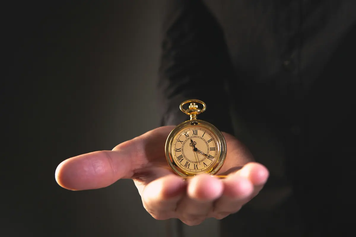 A gold pocket watch resting in an open palm, framed by the app’s scanning viewfinder